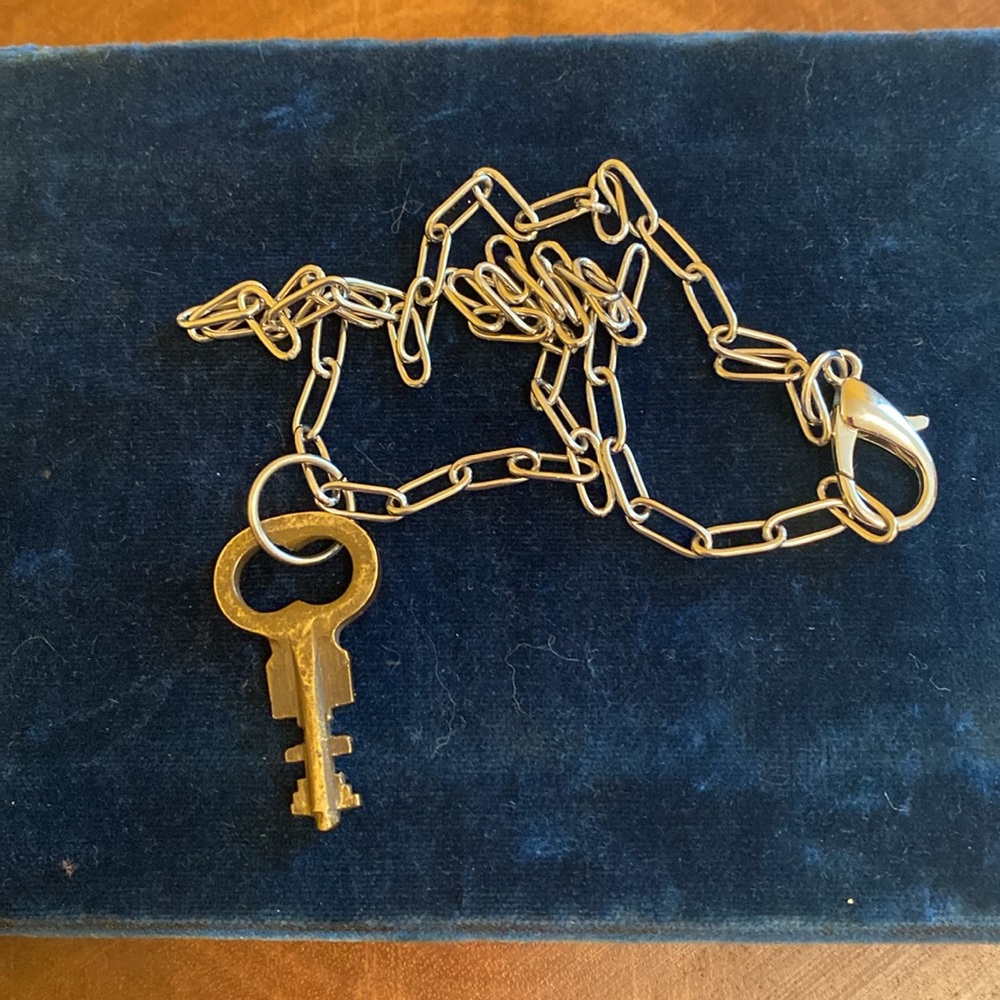 Vintage brass key on stainless steel paperclip chain